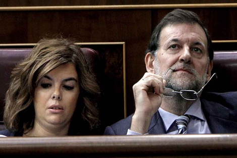 Rajoy, en su escaño, junto a Soraya Sáenz de Santamaría. | Efe