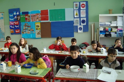 Un grupo de niños come en un colegio griego. height=313