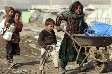 Niños afganos caminan por el campo de refugiados de Kabul. | Efe