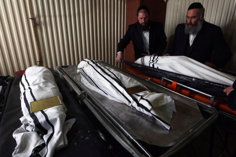 Miembros de la organización de judíos ultraortodoxos voluntarios ZAKA, con los cadáveres en Jerusalén.| Efe