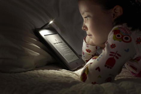 Una niña lee en un Kindle Touch de Amazon. | Efe