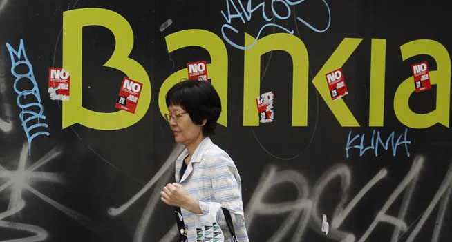 Una mujer pasa junto a una sucursal de Bankia en Madrid. | Reuters