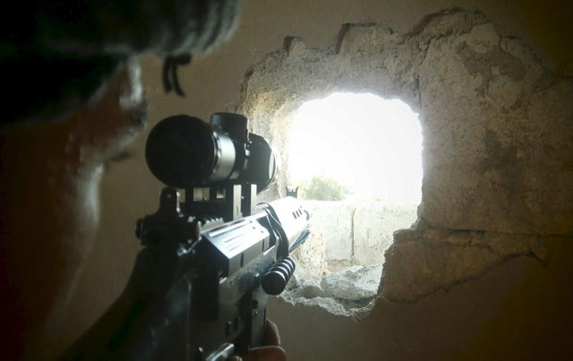 Un soldado del ejército libre de Siria apunta a su objetivo en un barrio de Homs.| Reuters