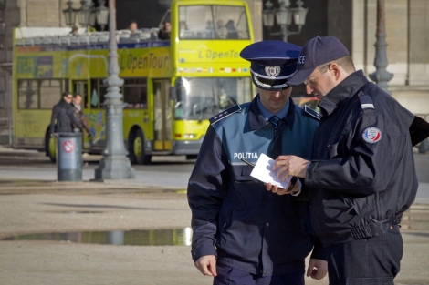 Un policía fránces muestra un mapa de París a un policía rumano. | AFP Un policía fránces muestra un mapa de París a un policía rumano. | AFP