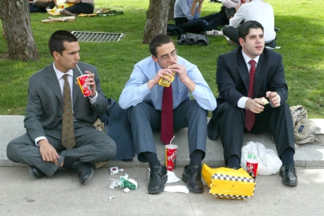 Tres ejecutivos toman comida rápida en un descanso del trabajo.| El Mundo