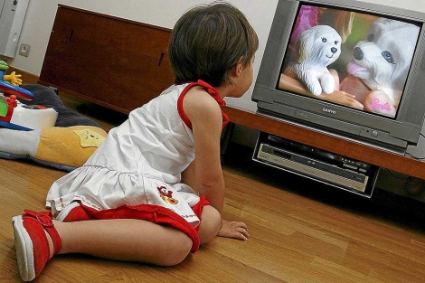Una niña pequeña ve la televisión. | R. Pérez